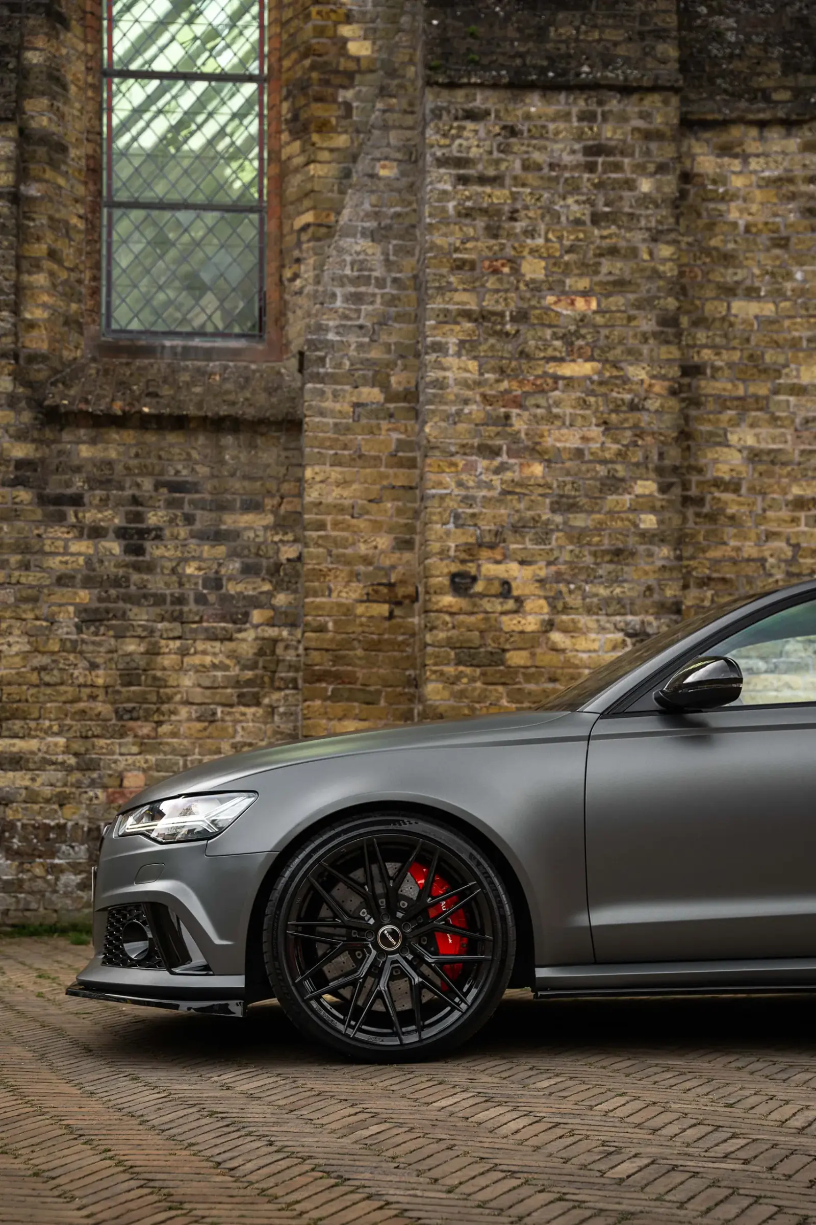 Zijaanzicht van de Audi RS6 met zwarte velg en rode remklauw
