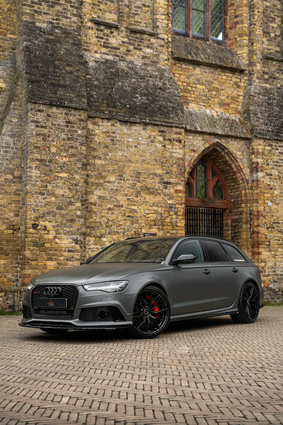 Audi RS6 met satijngrijze uitstraling en zwarte velgen, schuin van voren